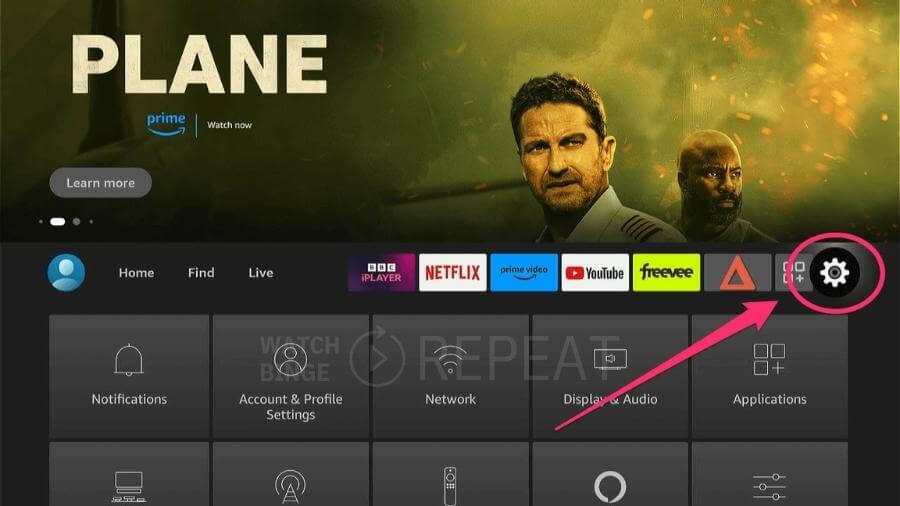 A firestick interface with a highlighted gear icon for settings. At the top, an ad for the movie "PLANE" on Prime is displayed.