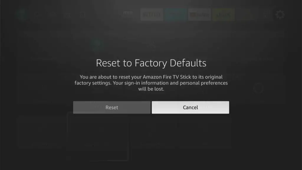 Confirmation dialog box for resetting to factory defaults on a blurred Fire TV settings background, with options to cancel or proceed with the reset