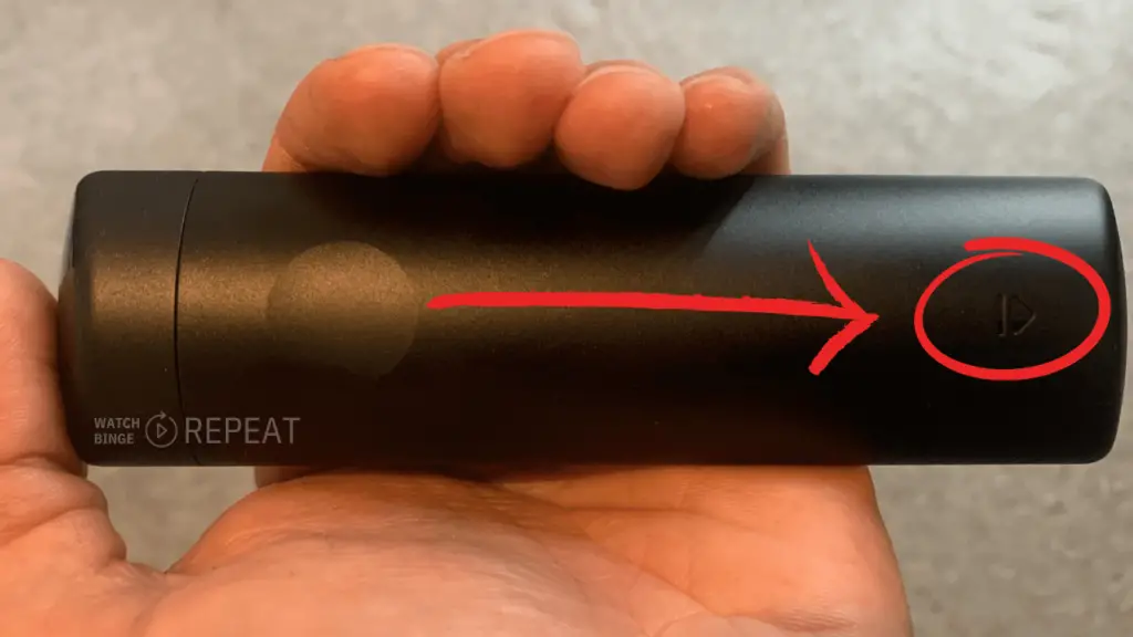 Triangle on the firestick remote showing the direction in which user should push the compartment cover