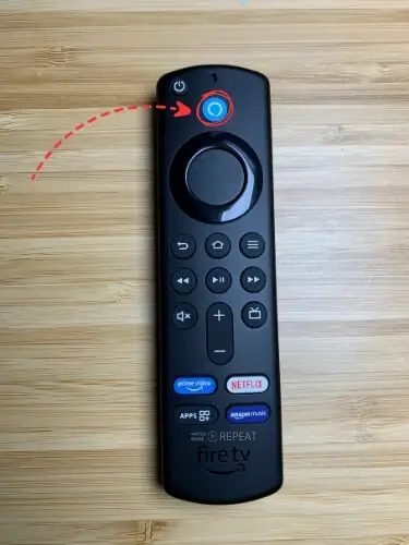 Firestick remote with Alexa button highlighted and pointed on with red arrow