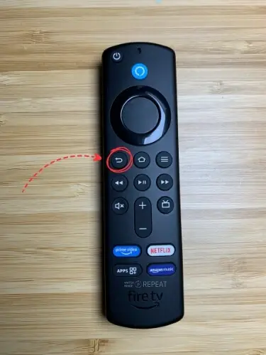 Firestick remote with Back button highlighted and pointed on with red arrow