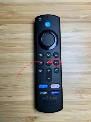 Firestick remote with Fast forward button highlighted and pointed on with red arrow