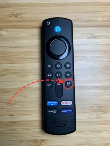 Firestick remote with Live TV button highlighted and pointed on with red arrow