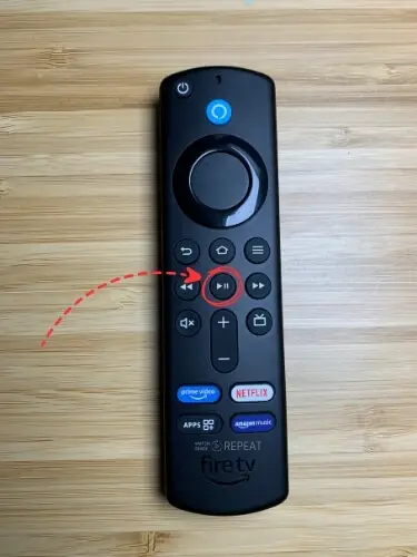 Firestick remote with Pause / play button highlighted and pointed on with red arrow